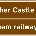Junction ahead from a motorway exit slip road to the tourist attractions shown