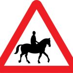 Accompanied horses or ponies likely to be in or crossing road ahead