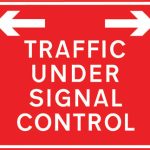 Traffic on road ahead is being controlled by portable light signals